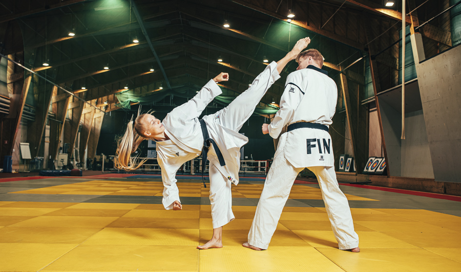 Karateka Titta Keinänen potkaisemassa korkealle vastustajan pään yläpuolelle.