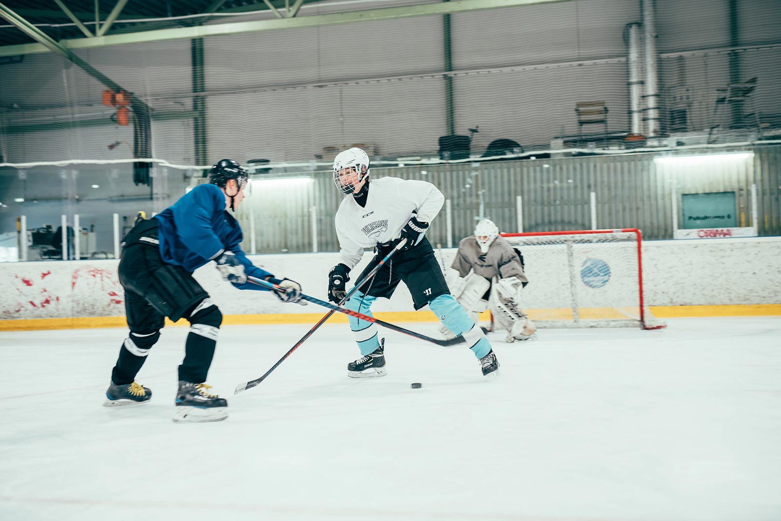 Jääkiekkoilijat pelaavat toisia vastaan pelitilanteessa Pajulahden jäähallissa.