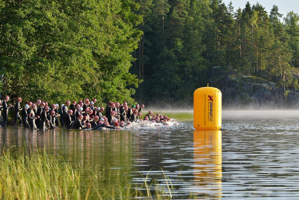 Kilpailijoita juoksemassa triathlon-kilpailun uintiosuudelle Pajulahdessa.